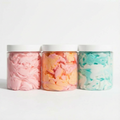 Three containers of colorful cotton candy on a white background