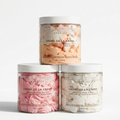 Three jars of 'Creme de la Creme' whipped body butter on a light gray background