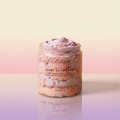 Jar of whipped body butter with a pink and white design on a gradient background
